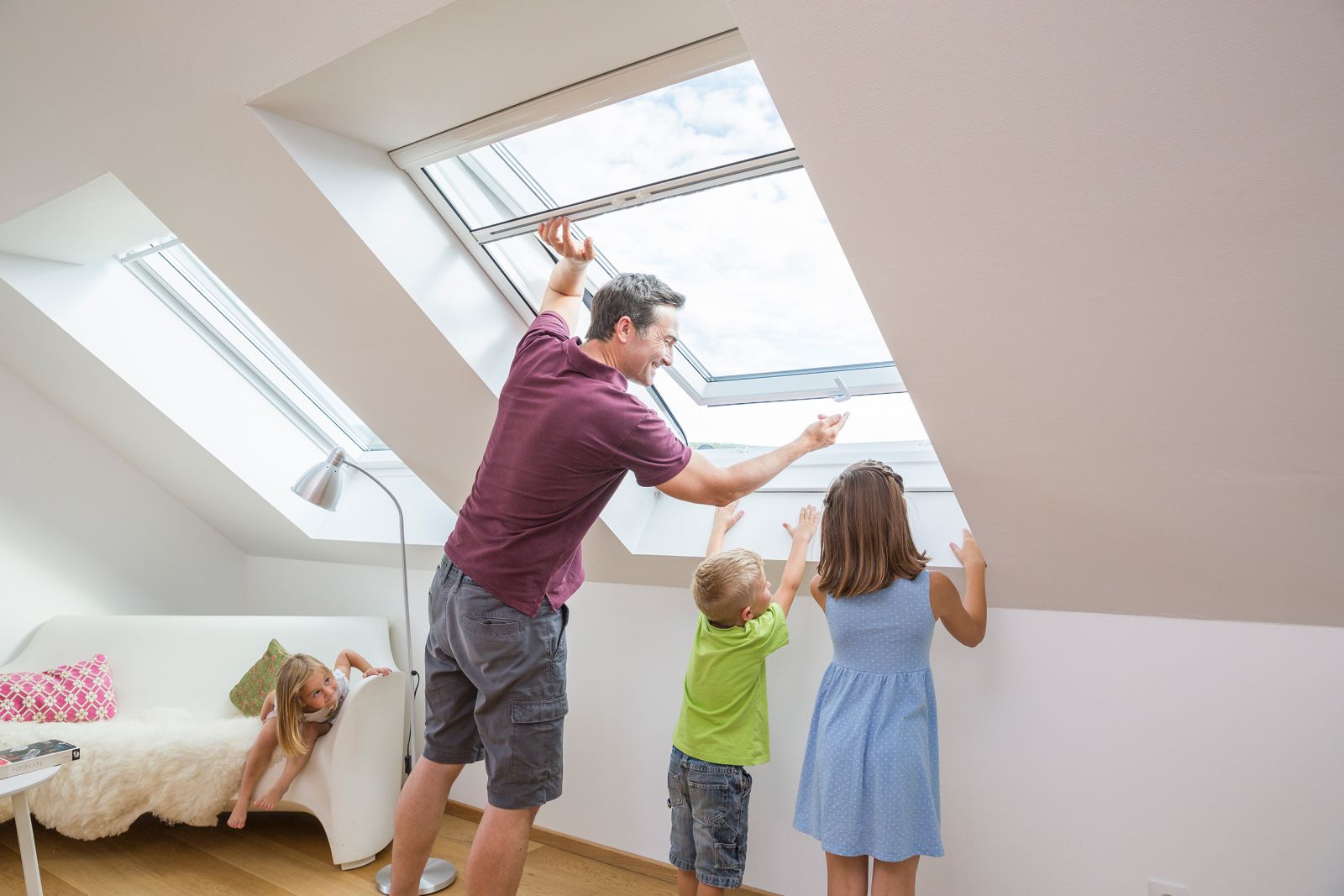 Mann mit Kindern steht an Dachfenster mit Fliegengitter